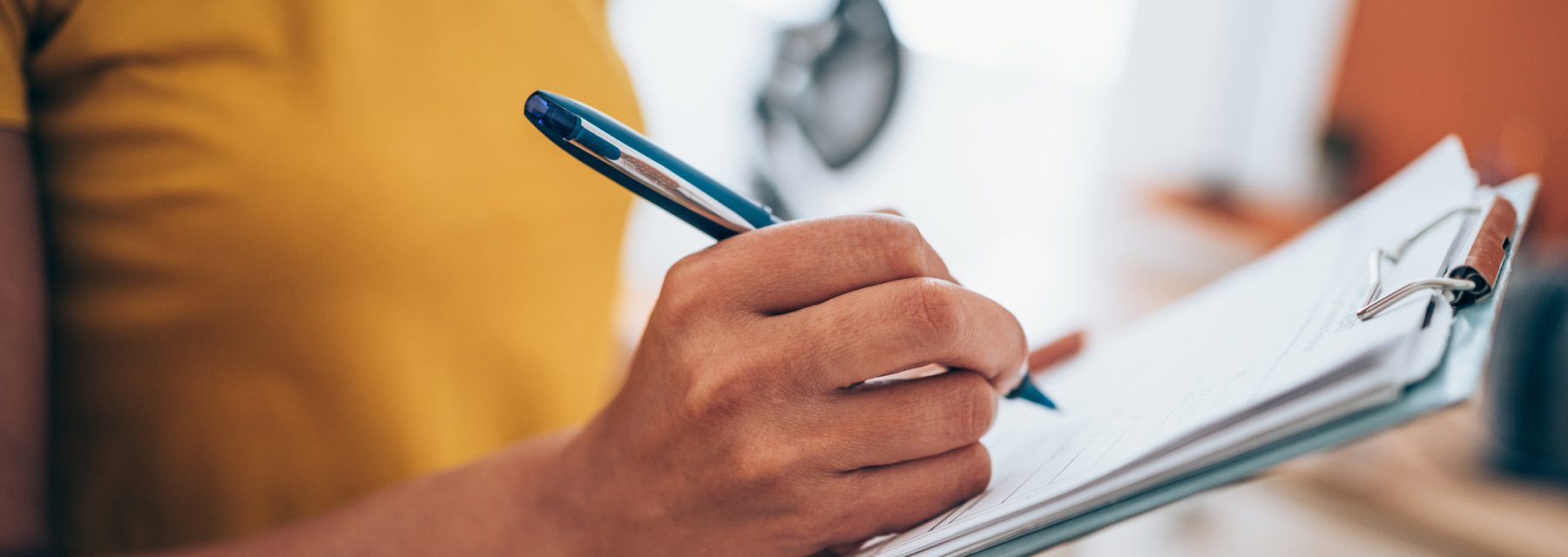 Close-up of a woman's hand as she writes on a clipboard at Pediatric Epilepsy & Neurology Specialists Tampa Florida