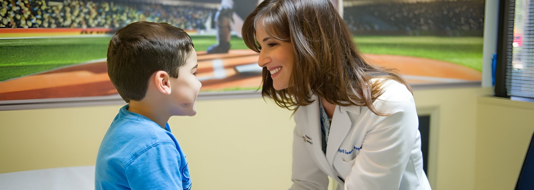 Woman in a white coat speaks to a boy at Pediatric Epilepsy & Neurology Specialists Tampa Florida